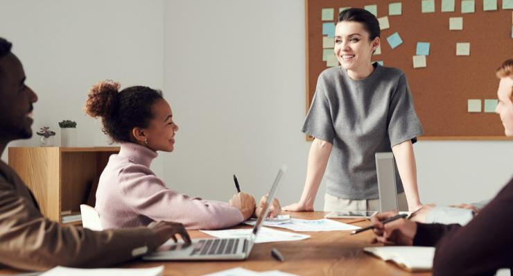 Woman teaching a class with children smiling.